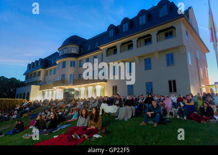 Spectators at an open-air movie night in front the Parliament building of the german-speaking Community in Eupen, Belgium. Stock Photo