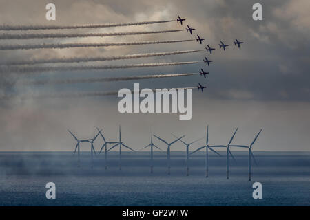 The Royal Air Force Aerobatic Team, the Red Arrows fly over the Gwynt y Mor windfarm off the North Wales Coast. Stock Photo