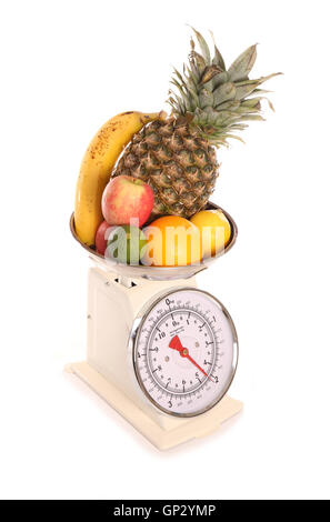 Balanced diet fruit on weighing scales cutout Stock Photo