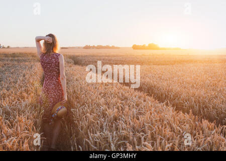 inspiration or waiting concept, happy beautiful young woman in sunset field, dream Stock Photo