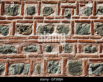Red thin brick and stone rough pattern wall background. Stock Photo