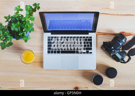 workplace of photographer, top view of gear, camera with lenses and laptop computer Stock Photo