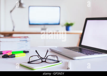 office interior background, glasses on the table, workplace with computer on the desk Stock Photo