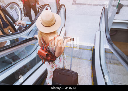 passenger in airport or modern train station, woman commuter with luggage Stock Photo