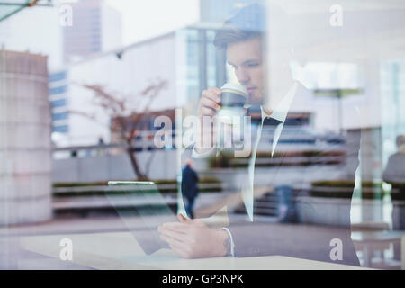 businessman reading news online and drinking coffee in airport cafe Stock Photo