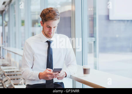 businessman reading news and emails on his smartphone Stock Photo