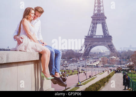 romantic love, affectionate couple sitting near Eiffel Tower in Paris, honeymoon in Europe Stock Photo