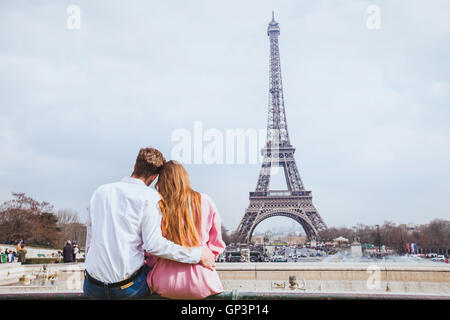 romantic couple looking at Eiffel tower in Paris, honeymoon background Stock Photo