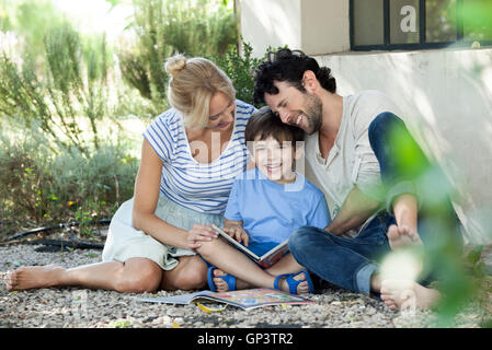 Parents reading book with child Stock Photo