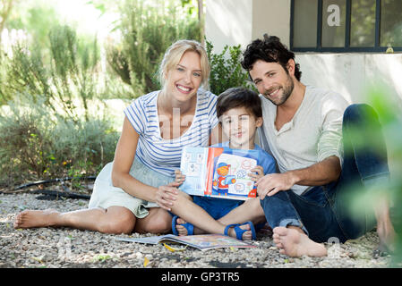 Parents together with child learning to read, portrait Stock Photo