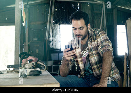 Man browsing internet with smartphone during work break Stock Photo