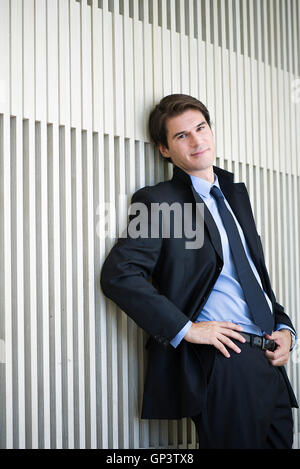 Businessman leaning against wall, portrait Stock Photo