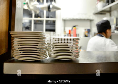 Stack of plates on shelf in commercial kitchen Stock Photo