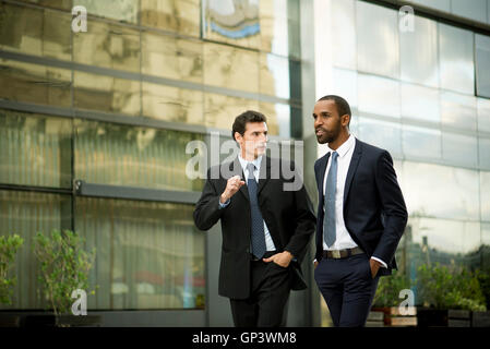 Businessmen walking and talking together Stock Photo