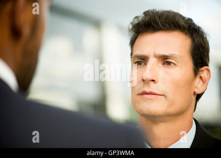 Businessman having serious conversation with colleague Stock Photo