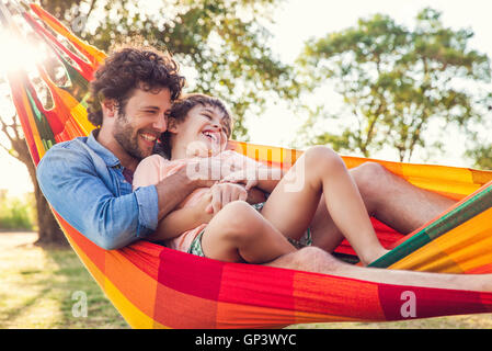 Father and son relaxing together in hammock Stock Photo