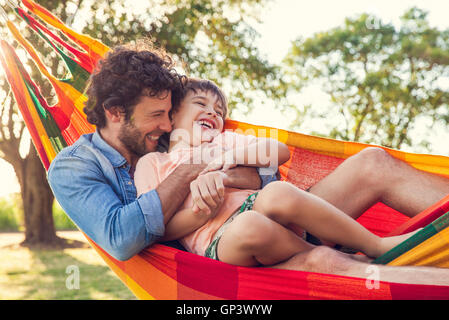 Father and son relaxing together in hammock Stock Photo