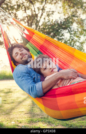 Father and son relaxing together in hammock Stock Photo