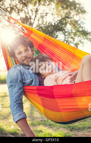 Father and son relaxing together in hammock Stock Photo