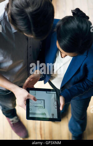 Viewing houseplan displayed on digital tablet Stock Photo