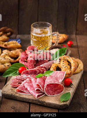 Glass of beer, pretzels and various sausages on wooden background. Oktoberfest. Stock Photo