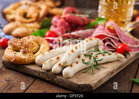 Glass of beer, pretzels and various sausages on wooden background. Oktoberfest. Stock Photo