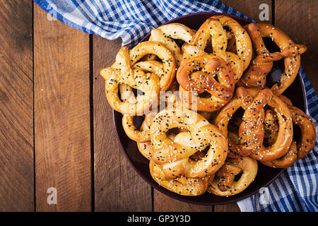 Oktoberfest salted soft pretzels in a plate from Germany on wooden background. Top view Stock Photo