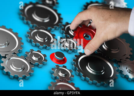 Close-up of a hand holding a red gear and positioning it at the right place. Abstract concept of leader or partnership. Composit Stock Photo