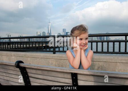 Little girl resting on pier near New York City, New York, USA Stock Photo