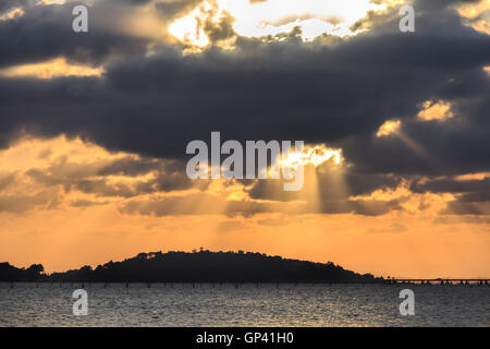 Partly cloudy sunset mountain reflections sea colors. Stock Photo