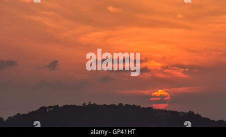 Partly cloudy sunset mountain reflections sea. Stock Photo