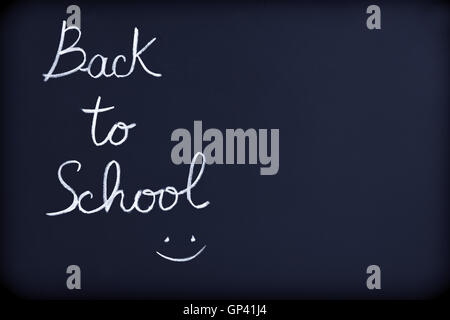 Back to school background, conceptual phrase with drawing of a smiley face on the blackboard, beginning of educational season Stock Photo