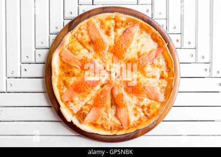 Pizza with smoked salmon and egg on white wooden table Stock Photo