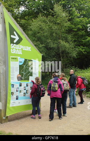 Visitors survey the information board at the start of the Sculpture Trail in the Forest of Dean, Beechenhurst, Gloucesterhire Stock Photo