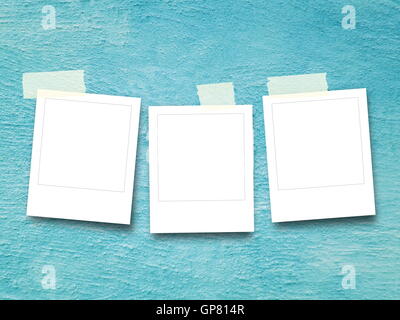 Close-up of three blank square instant photo frames with adhesive tape on aqua plastered concrete wall background Stock Photo