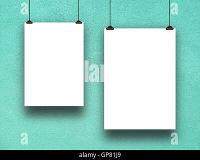 Close-up of two blank frames hanged by clips against aqua rough plastered concrete wall background Stock Photo