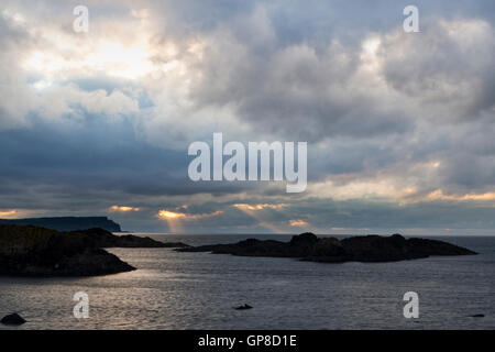 Sun rays bursting through thick cloud Northern Ireland landscape Stock Photo