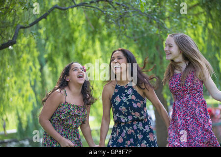 Happy Hispanic mother and two teen daughters having fun in the park Stock Photo