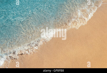 Soft foaming wave of blue sea on a sand beach. Summer vacation background, holiday recreation concept Stock Photo