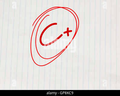 C plus (C+) grade written in red on notebook paper Stock Photo