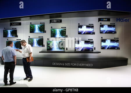 Berlin, Germany. 2nd Sep, 2016. Attendees talk in front of Haier's smart TVs at Haier's stand during the 2016 IFA consumer electronics fair in Berlin, Germany, on Sept. 2, 2016. Over 700 Chinese companies have taken part in IFA 2016 with their latest product highlights and services. © Zhang Fan/Xinhua/Alamy Live News Stock Photo