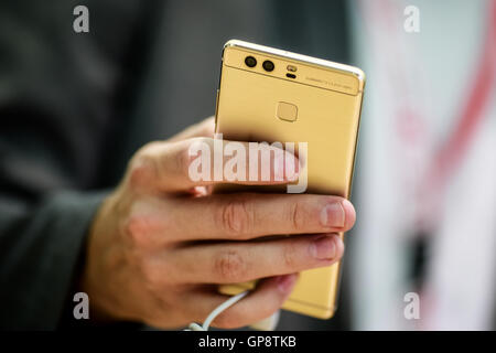 Berlin, Germany. 2nd Sep, 2016. A staff member displays a Huawei P9 smart phone at Huawei's stand during the 2016 IFA consumer electronics fair in Berlin, Germany, on Sept. 2, 2016. Over 700 Chinese companies have taken part in IFA 2016 with their latest product highlights and services. © Zhang Fan/Xinhua/Alamy Live News Stock Photo