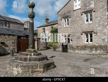 Ancient stone cross in the Swinemarket at Kirkby Lonsdale in Cumbria Stock Photo