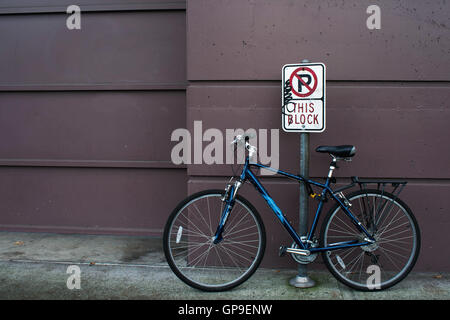 Bicycle leaning on a no parking sign. Stock Photo