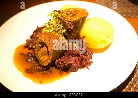 A beef roulade is served in the city of Gotha, Germany. The dish is served with red cabbage and potato dumpling. Stock Photo