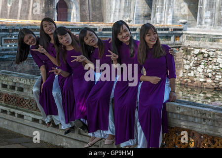 Girls in traditional 'ao dai' costume pose outside the Imperial City, Hue, Viet Nam Stock Photo