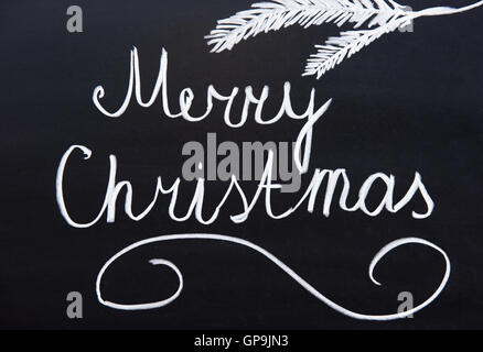 Merry Christmas written on a blackboard with chalk Stock Photo