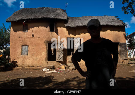 Man in front of his traditional house ( Madagascar). The scene takes place in the central highlands. Stock Photo
