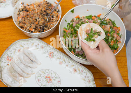 lady making wontons at home Stock Photo