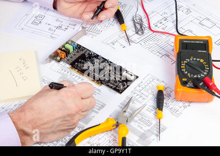 Electronics engineer making changes to a computer circuit wiring diagram Stock Photo